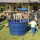 Aluna da UFGD e criança moradora do Itamaraty ao lado do sistema de aquaponia