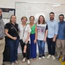 Na foto estão oito pessoas, lado a lado, ao fundo se vê um quadro de sala de aula
