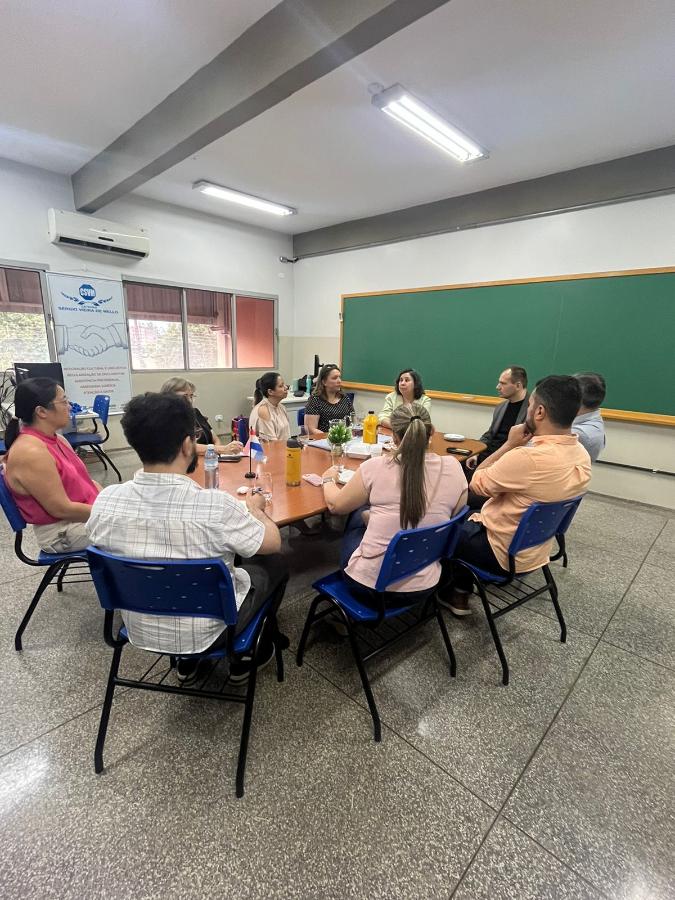oito pessoas sentadas em volta de uma mesa