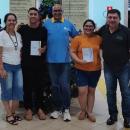 Enrique Duarte Romero entregando os glossários para dois estudantes estrangeiros da FACE. 
