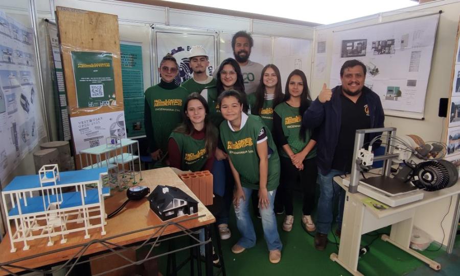 No estande de Engenharia Civil, maquetes e maquinário demonstram áreas de estudo do curso. Faculdades Abertas